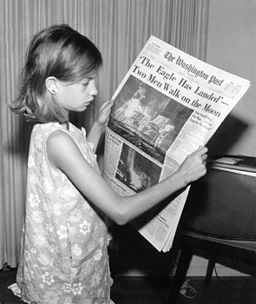 Niña leyendo el periódico